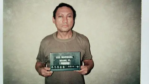 Getty A sad-looking middle-aged man in a tee shirt poses for a mug shot.