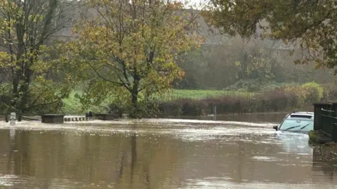 Warwickshire Police A car that has been submerged in floodwater.