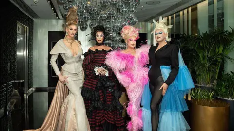 Getty Images Silllexa Dixon wearing a cream and green dress, Bones wearing a black and red dress, Elle Vosque wearing a pink and black dress and Catrin Feelings wearing a black and blue dress.