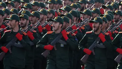 A picture of soldiers in a dark green uniform and red gloves. 