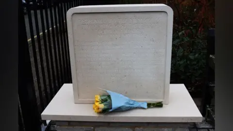 Hertsmere Borough Council A memorial stone with yellow roses placed beside it