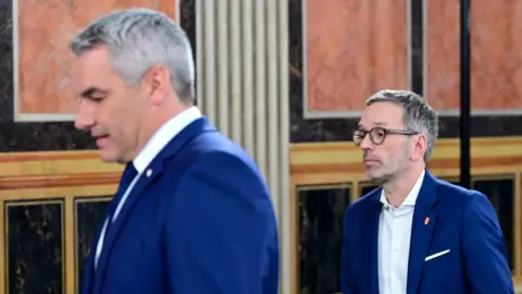 ROLAND Schlager/APA/AFP Austrian Chancellor, president and main candidate of the Austrian People's Party (OeVP) Karl Nehammer and president and main candidate of the right-wing populist Freedom Party of Austria (FPOe) Herbert Kickl on September 29 in Vienna