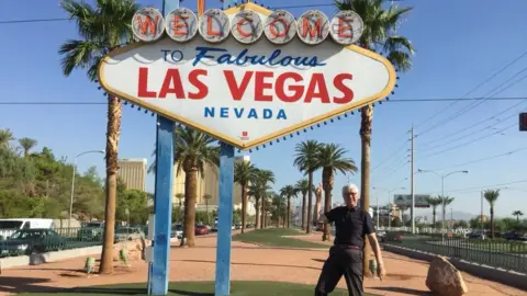 Supplied Nigel Thomas is pictured a few years ago on holiday in Las Vegas. He is standing beneath one of the famous road signs that welcomes visitors to Las Vegas. It is large, lozenge-shaped, and has red and blue writing on a white background saying 'welcome to fabulous Vegas Nevada'.