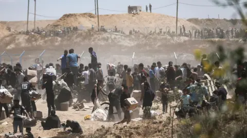 EPA File photo showing Palestinians collecting aid from the US-backed Gaza Humanitarian Foundation in the Netzarim Corridor, central Gaza Strip (29 May 2025)