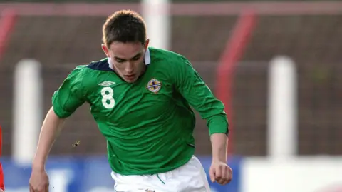 Getty Images Kieran McKenna wearing a Northern Ireland top playing football