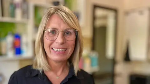 Martin Giles/BBC Nicky Rivett is wearing a black shirt and glasses.