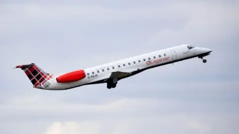 A Loganair plane takes off. It is a small white aircraft with red engines and a tartan design on the tail