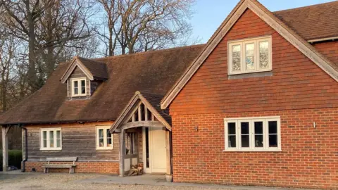 Simon Broad A brown house with a white front door