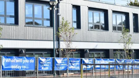 St Ralph Sherwin Catholic Multi Academy Trust A photograph of the new science block. It is a building with grey panels and windows with black frames. 