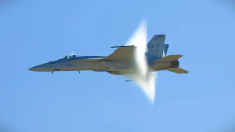 Image of jet at the moment it creates a sonic boom. 