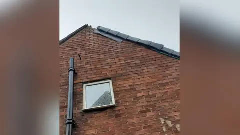 Lancashire County Council handout Roof of brick house left with part of the lead flashing missing.