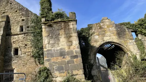 A derelict-looking old building covered in ivy