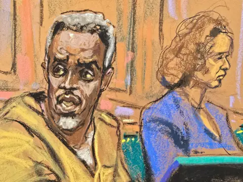 Reuters A court sketch of Sean 'Diddy' Combs talking to his lawyer. His eyes look heavy set and his hair is greying.