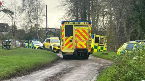 Wiltshire 999s Two ambulances and several police cars parked in countryside