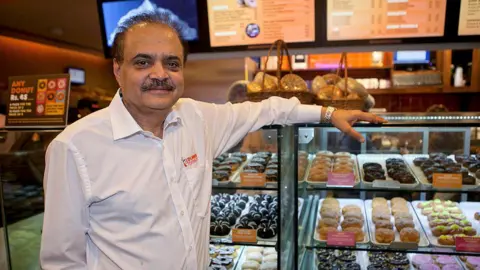 Shyam Sunder Bhartia, chairman of Jubilant Foodworks Ltd., poses for a photograph in the newly opened Dunkin' Donuts store in New Delhi, India, on Tuesday, May 8, 2012