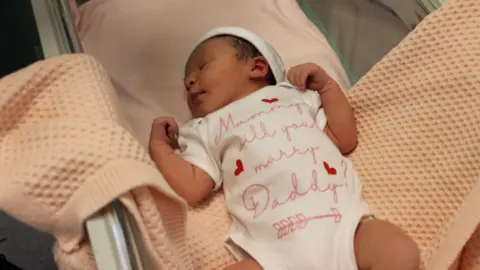 James Cook University Hospital Paloma Taylor wearing baby grow which says ‘mummy will you marry daddy?’