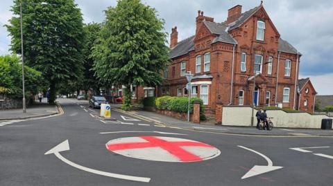 A St George's Cross painted on a white mini-roundabout