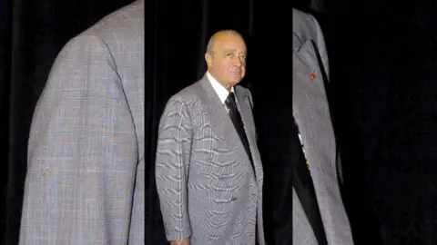 Mohamed Al Fayed wears a grey suit