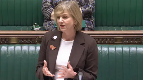 House of Commons Transport Minister Lillian Greenwood wearing a brown jacket and white shirt speaking in the House of Commons  
