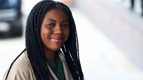 Reuters Kemi Badenoch smiles to photographers as she arrives at the Conservative Party's annual conference in Birmingham