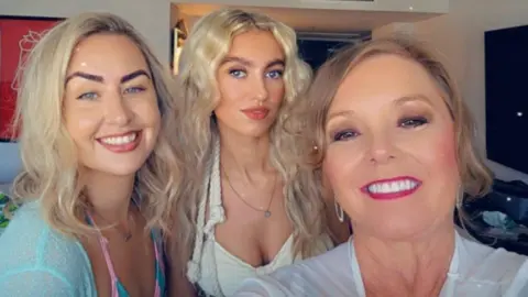 Supplied Three women with light coloured hair are smiling at the camera