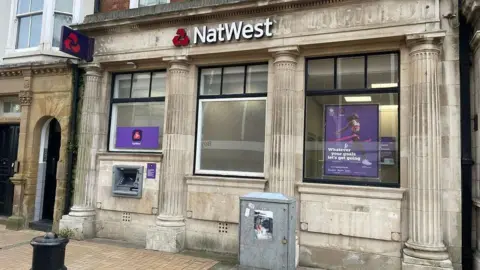 The outside of a NatWest branch in a high street 