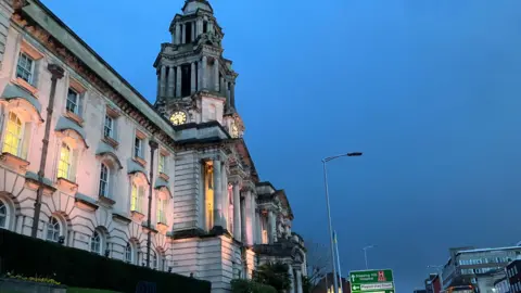 Local Democracy Reporting Service Stockport Town Hall, a large white grand building, is seen from the street below.