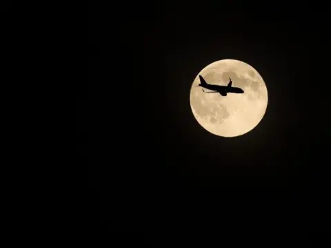 Bubs A silhouette of a level   crossing the supermoon.