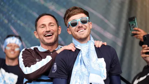 PA Media Frank Lampard is on stage with his hands on the shoulders of midfielder Josh Eccles