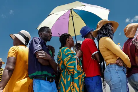 Simon Maina / AFP Voters queue at a polling station at the Sam Nujoma stadium in Windhoek.