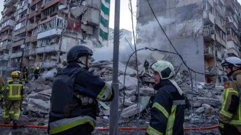 Fire crews survey scene of apartment strike in Kyiv 