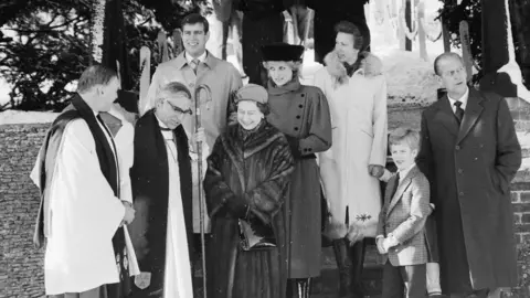 Getty Images DECEMBER 25: (L-R) Prince Andrew, Duke of York, Queen Elizabeth II, Diana, Princess of Wales, wearing a red military style coat designed by Piero de Monz, a black velvet crowned hat designed by Marina Killery and a Russian style black muff, Anne, Princess Royal, Peter Phillips and Prince Philip, Duke of Edinburgh. They all leave St Mary Magdalene Church after attending the Christmas Day service on December 25, 1985 in Sandringham, United Kingdom