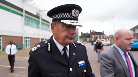 PA Media Nick Adderley with short dark hair in a police uniform in the Northampton Saints car park