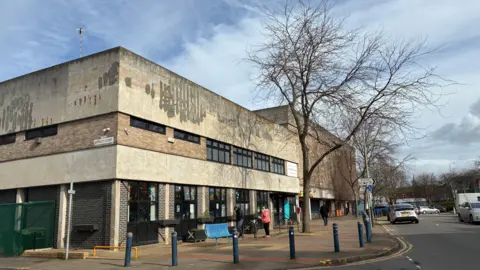 LDRS St Matthews Community Centre on Malabar Road in Leicester. The building has brick pillars between windows and then a grey concrete render above, stained by the weather.