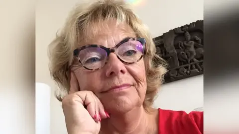 Dr Susan Phoenix wearing glasses and a red top