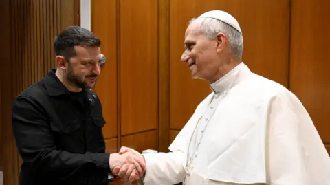 Reuters Ukraine's President Volodymyr Zelenskiy shakes hands with Pope Leo XIV on the day of his inaugural Mass in St. Peter's Square, at the Vatican, May 18, 2025