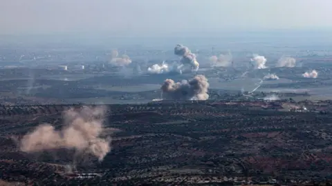 Anadolu Smoke rises from multiple locations on the outskirts of Saraqeb in north-west Syria during a rebel offensive against government forces, as seen from Ariha (28 November 2024)