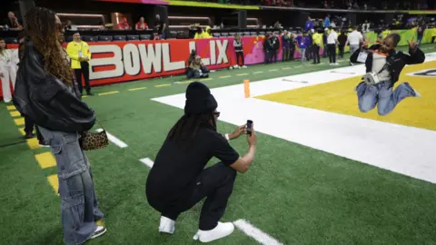 Reuters Jay-Z took a few photos of Rumi jump next to one of the endzones as Blue Ivy watches on