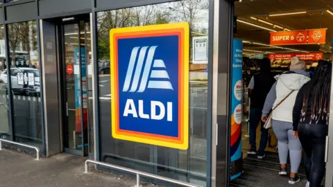 An Aldi storefront with people entering through the doors