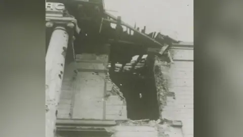 Madeleine Resühr In a black and white photograph we get a brief insight into the damaged caused to the church during the bombings of World War Two. Pictured is a large hole in the side of the building as well as exposed wood in the roof.