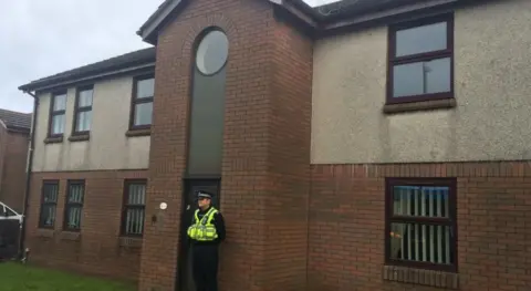 Police officer outside the trem y cwm flats in 2015