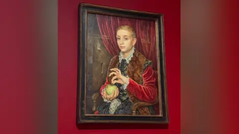 Michael Taylor Boy with Apple portrait against a red background.