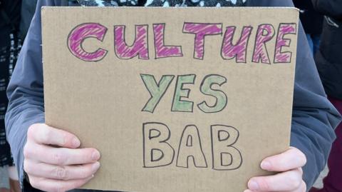 Protester holding a placard that read "culture yes bab" calling to stop cuts to the arts budget in Birmingham