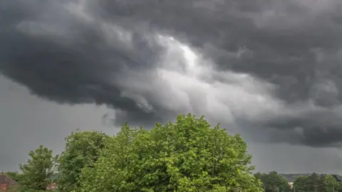 Getty Images Storm clouds gathering over playing fields.