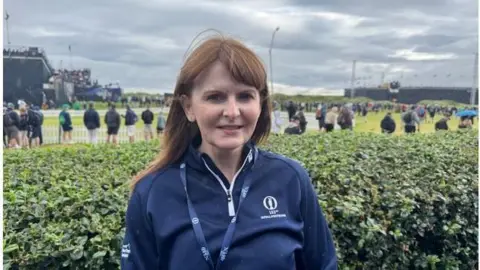 Caoimhe Archibald, in blue top, at The Open at Royal Portrush, with spectators in the background.