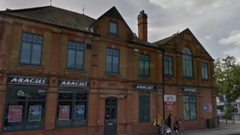 Google A large derelict red brick building with "Abacus" branding above four of the windows.