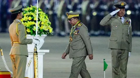Military Chief Min Aung Hlaing arrives to deliver a speech during a ceremony to mark Myanmar's Armed Forces Day in Naypyidaw on March 27, 2026