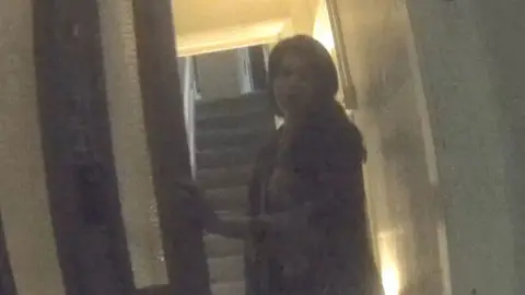 Woman opening a front door to a house