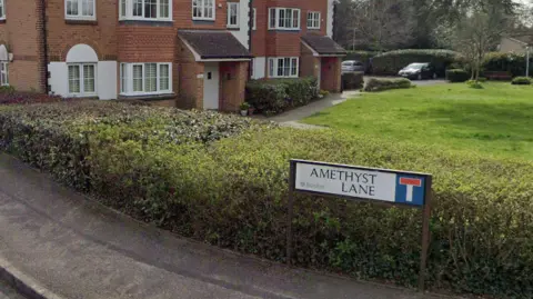 Google A sign saying Amethyst Lane on a residential road. 