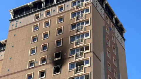 Black charring around the window of a tower block